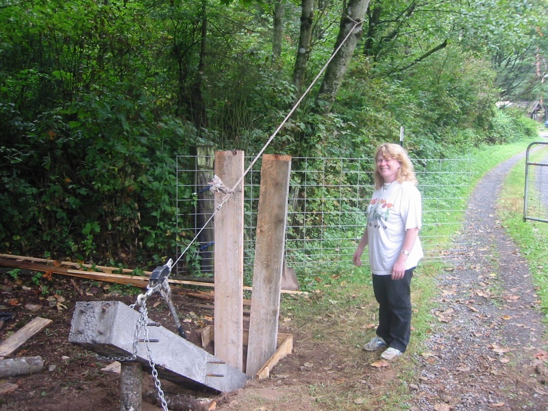 Raising the gate post, boards protect the far wall of the hole